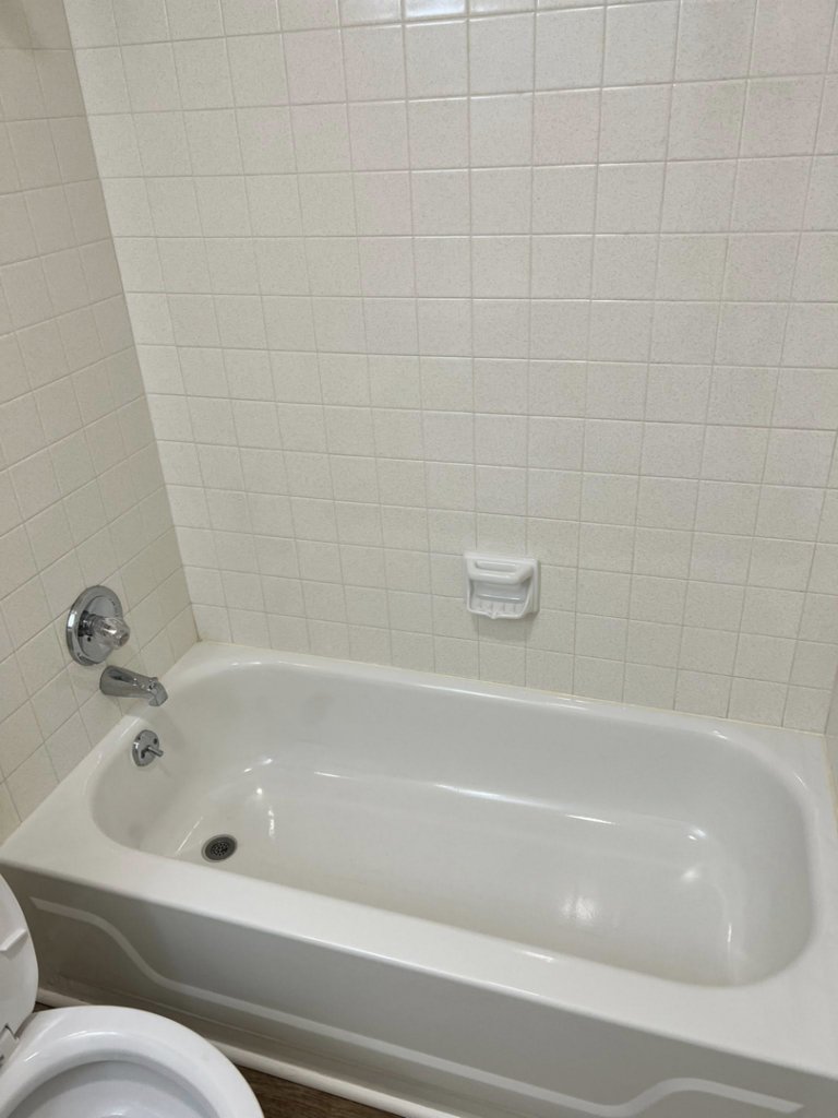 A freshly cleaned white bathtub and tiled shower in a bathroom by Treadway's Cleaning Services in Spencer, IN