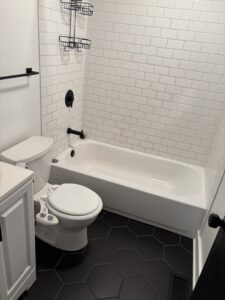 A freshly cleaned residential bathroom with a toilet, bathtub, and white subway tiles, by Uniquely Clean Professional Services in Kansas City, MO.