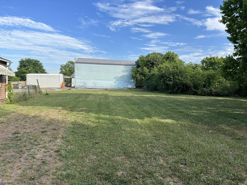 A freshly mowed lawn with neat stripes next to a commercial building, maintained by Taylor's Trimmings in Parkersburg, WV.