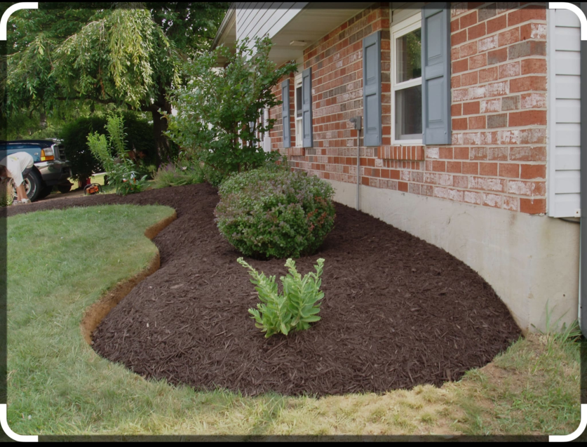 A freshly mulched garden bed and landscaping work by Amazing Lawns & Lighting for a home in Omaha, NE.