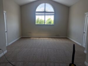 A freshly vacuumed bedroom with clean carpet and a large window, demonstrating house cleaning by Columbia Cleaners in Columbia, MO.
