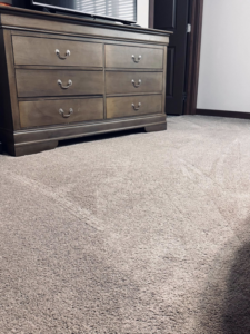 A freshly vacuumed bedroom carpet with clear lines, showcasing clean results by Dust Detail Cleaning Services in Post Falls, ID.