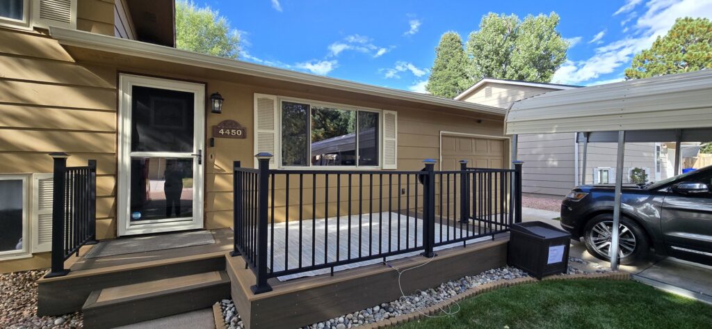 Front of a house with new tan siding and a welcoming porch, completed by EZ General Construction in Colorado Springs, CO.