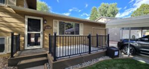 Front of a house with new tan siding and a welcoming porch, completed by EZ General Construction in Colorado Springs, CO.