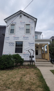 Front of a residential house fully wrapped in Tyvek HomeWrap, ready for siding installation by Lap Vinyl Siding Repair Columbus OH.