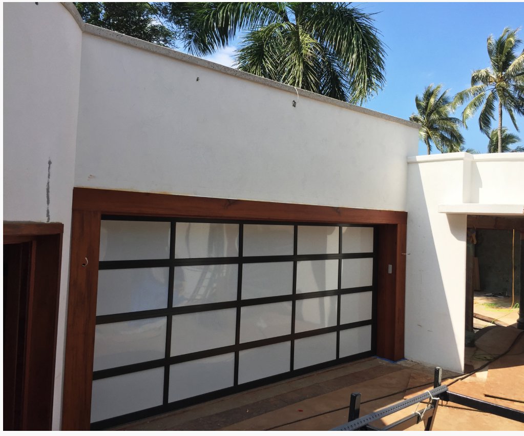 A newly installed modern garage door with frosted glass panels by Oahu Garage Doors in Waipahu, HI