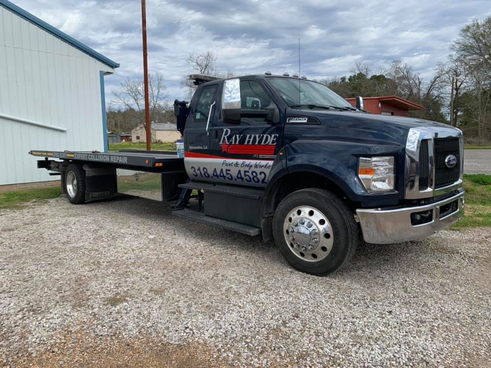 Full side view of a Ray Hyde Paint & Body Works flatbed tow truck in Alexandria, LA.
