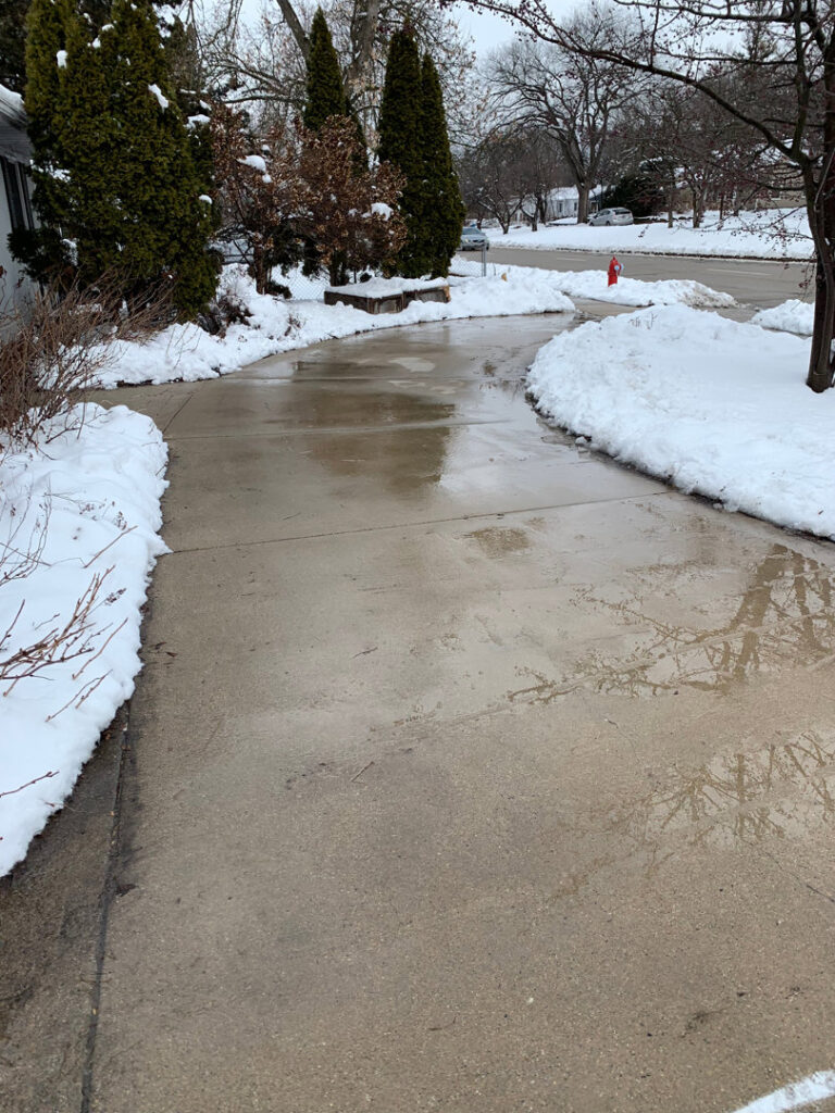A residential driveway fully cleared of snow by Snow Scholars - Snow Removal By College Students in Madison, WI.