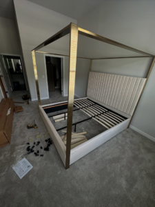 A partially assembled bed frame with tools and parts on the floor, showing furniture assembly by Mr Capitol Services llc in Laurel, MD.