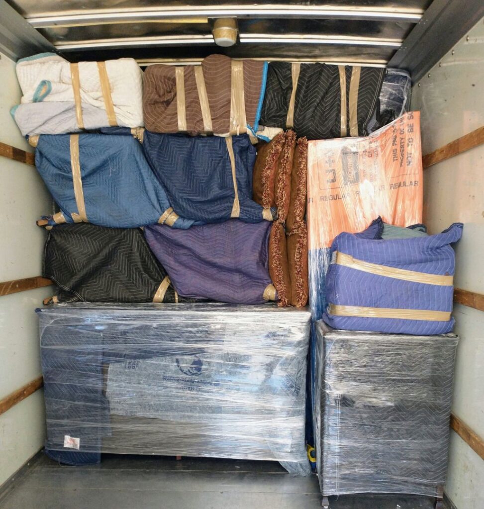 Furniture wrapped in moving blankets and plastic, securely packed in a Family Movers 615 LLC truck in Goodlettsville, TN.