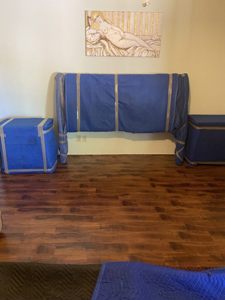 Bedroom furniture, including a headboard and side tables, expertly wrapped for moving by Moving Marvels in Tucson, AZ.