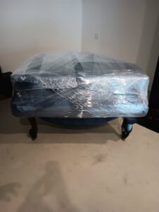 A piece of furniture expertly wrapped in plastic for safe transport by Packman Moving in San Diego, CA