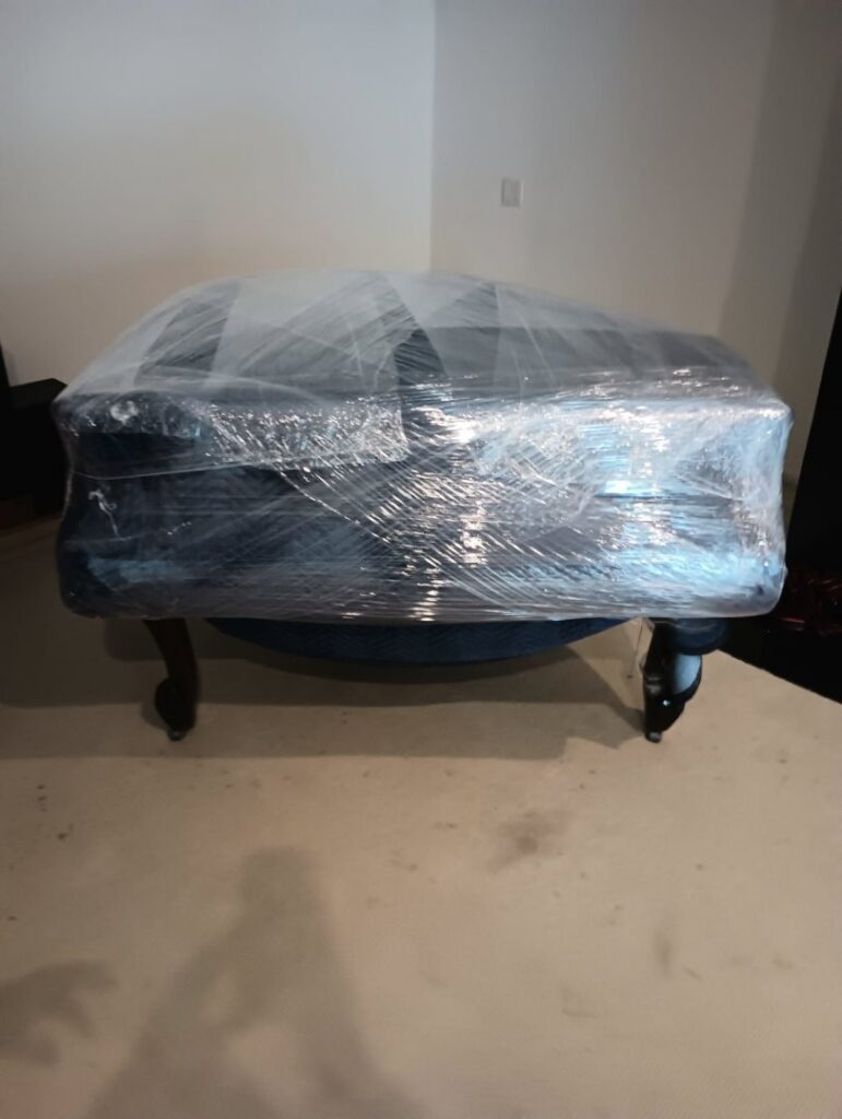 A piece of furniture expertly wrapped in plastic for safe transport by Packman Moving in San Diego, CA