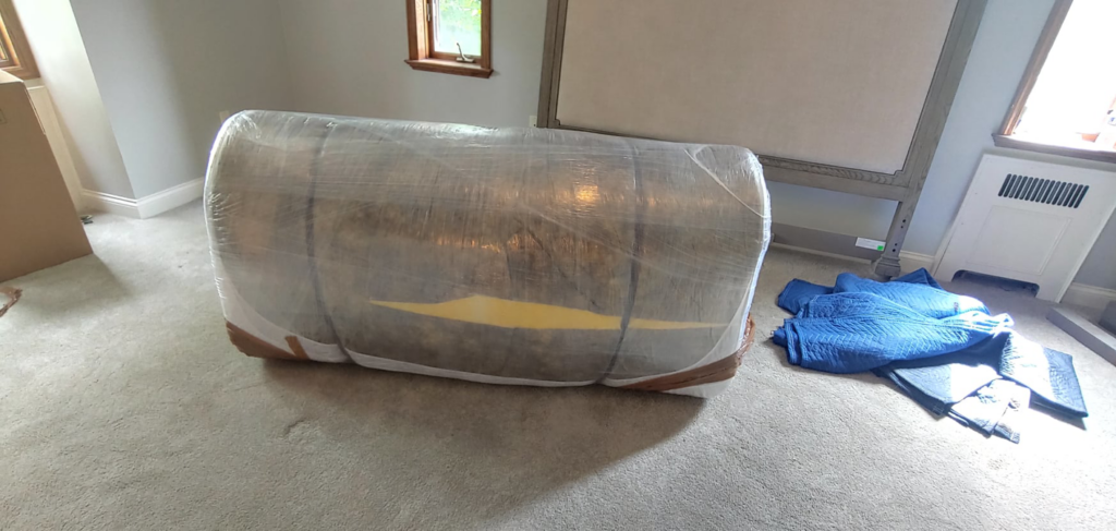 A large piece of furniture carefully wrapped for moving by Prime Moving Center in Pittsburgh, PA.