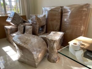 Various furniture pieces carefully wrapped in brown paper and plastic, with packing tape, by Orellana AV Moving in Miami, FL.