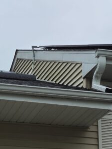 A close-up view of a house's gable vent, siding, and newly installed gutter by A&D Exteriors in Naperville, IL.
