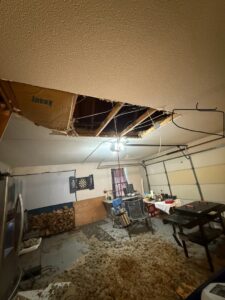 A garage with a collapsed ceiling, indicating severe water damage requiring repair by ABC Cleaning and Restoration in Harvest, AL.