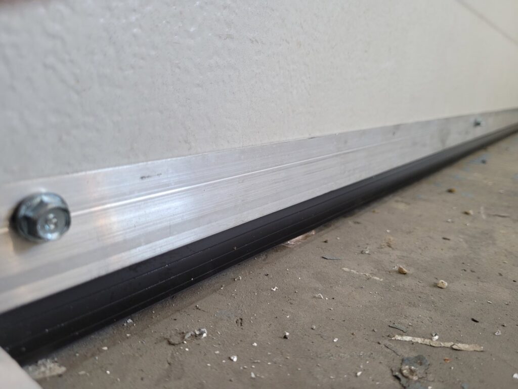 Close-up of a garage door bottom seal and weather stripping installed by Klondike Door Service in Fairbanks, AK