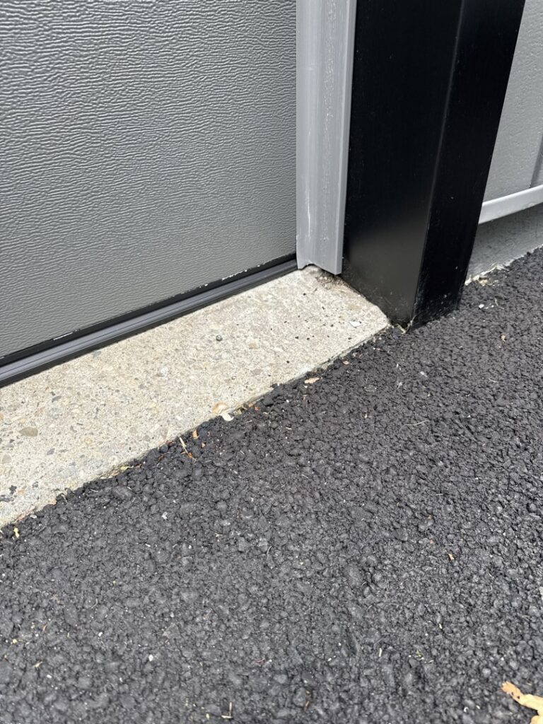 Close-up of a garage door bottom seal and concrete by Mascolo Overhead Doors & Maintenance in Brookfield, CT.
