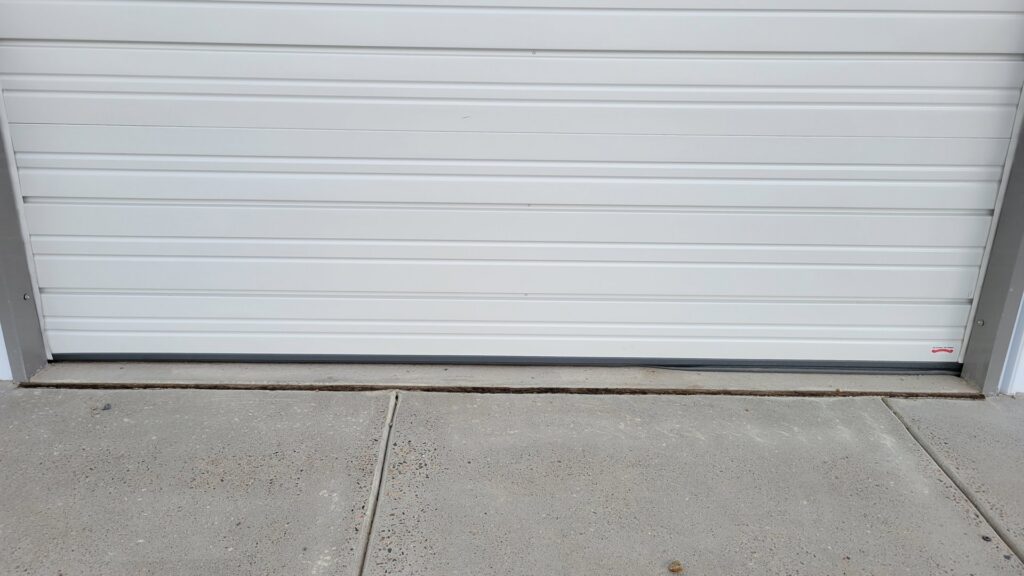 A close-up of the bottom of a garage door showing the weather seal, indicating quality installation by Overhead Door Company of Albuquerque in Albuquerque, NM.