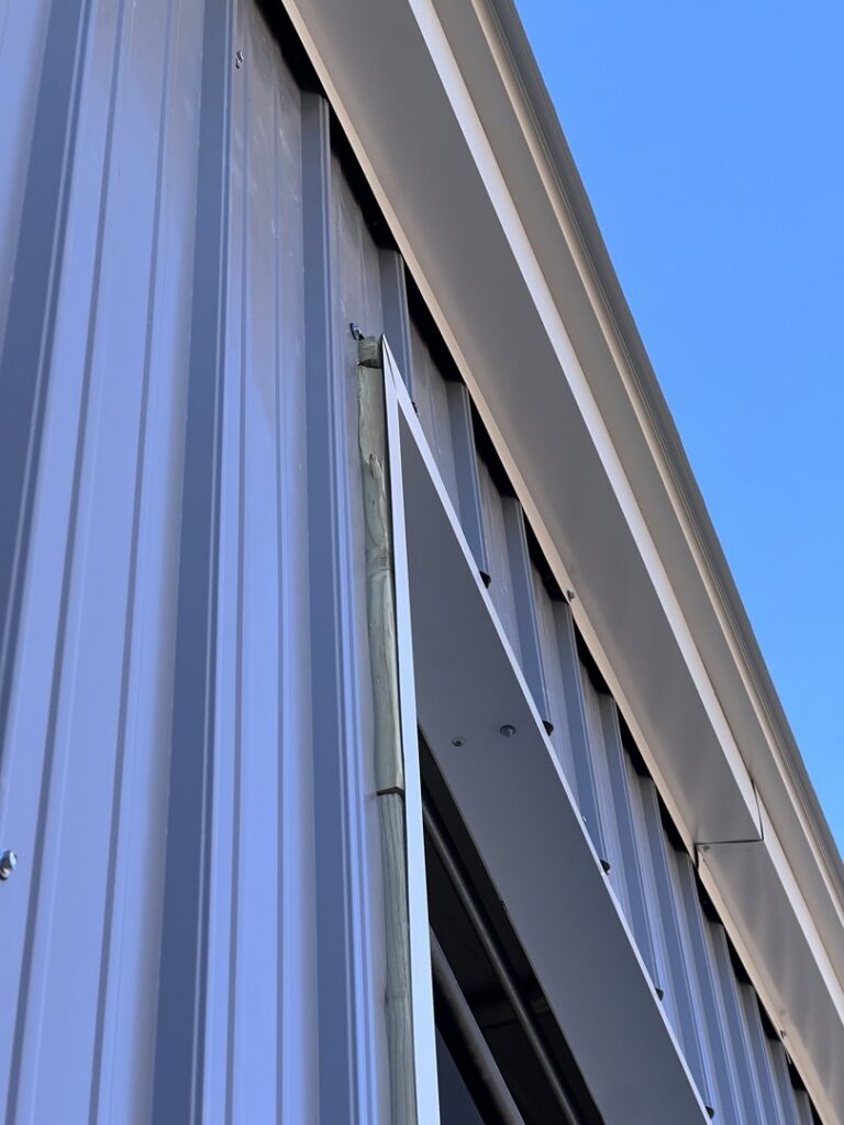A close-up of a garage door frame's top corner and trim, highlighting installation work by Overhead Door Company of Santa Fe in Santa Fe, NM.