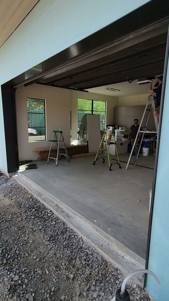 Garage door installation in progress at a construction site, showing the open frame and interior by North Idaho Garage Door in Coeur d'Alene, ID.