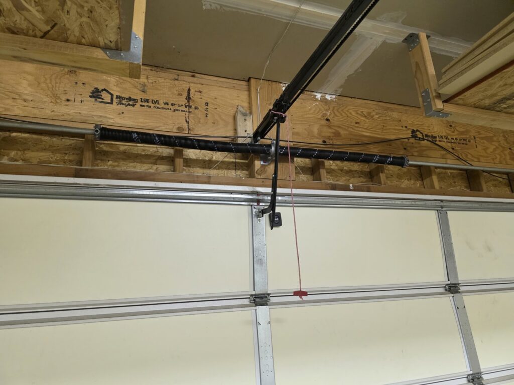 An interior view of a garage door opener and spring system, serviced by Barrett Overhead Doors in Idaho Falls, ID.
