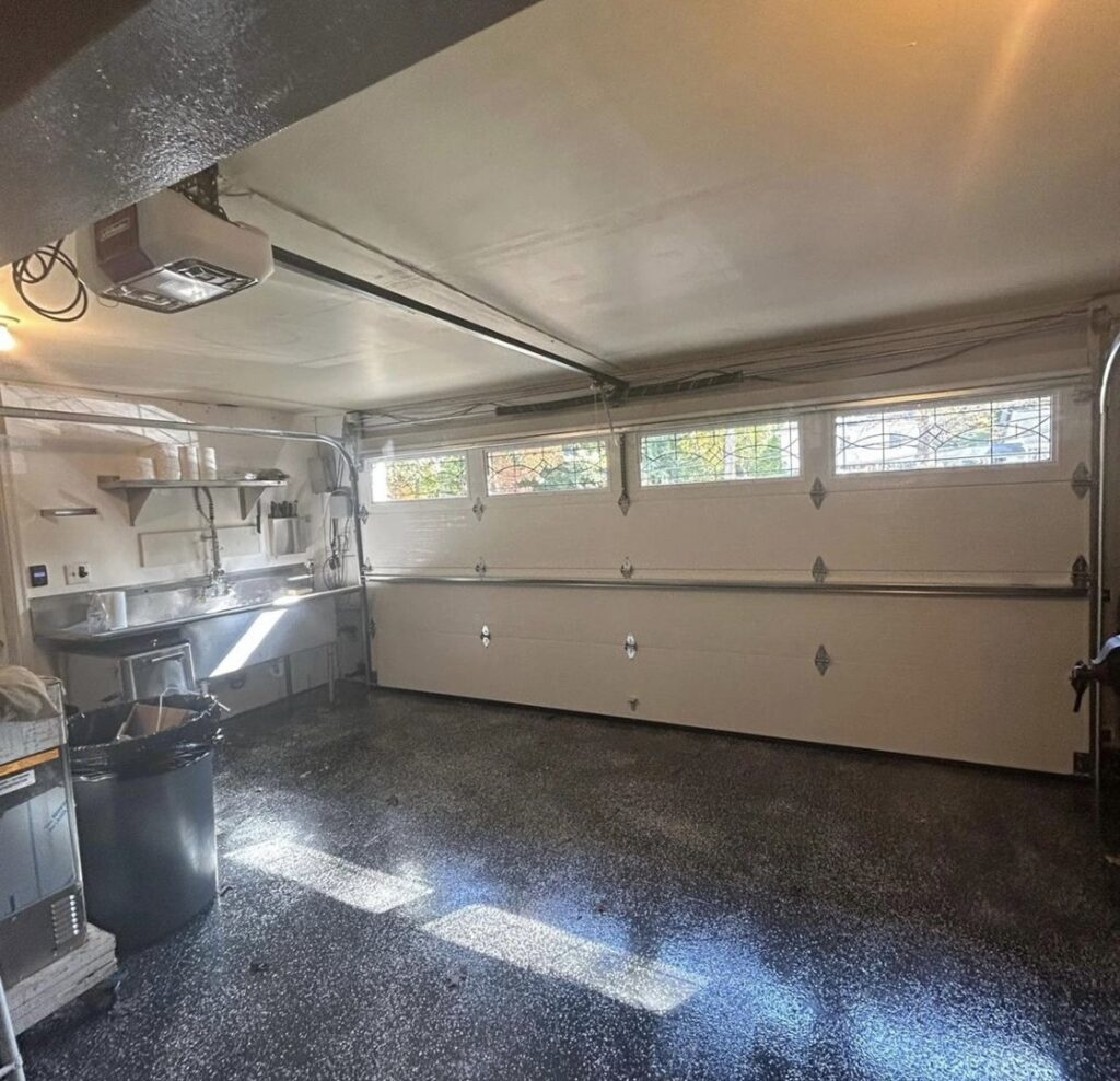Interior view of a garage showing a newly installed garage door, opener, and tracks by Mascolo Overhead Doors & Maintenance in Brookfield, CT.