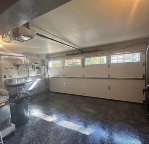 Interior view of a garage showing a newly installed garage door, opener, and tracks by Mascolo Overhead Doors & Maintenance in Brookfield, CT.