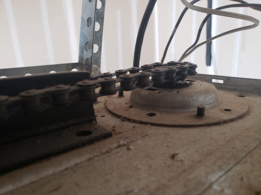 Close-up of a garage door opener's chain drive mechanism, indicating repair or maintenance by Right Choice Doors in Layton, UT.