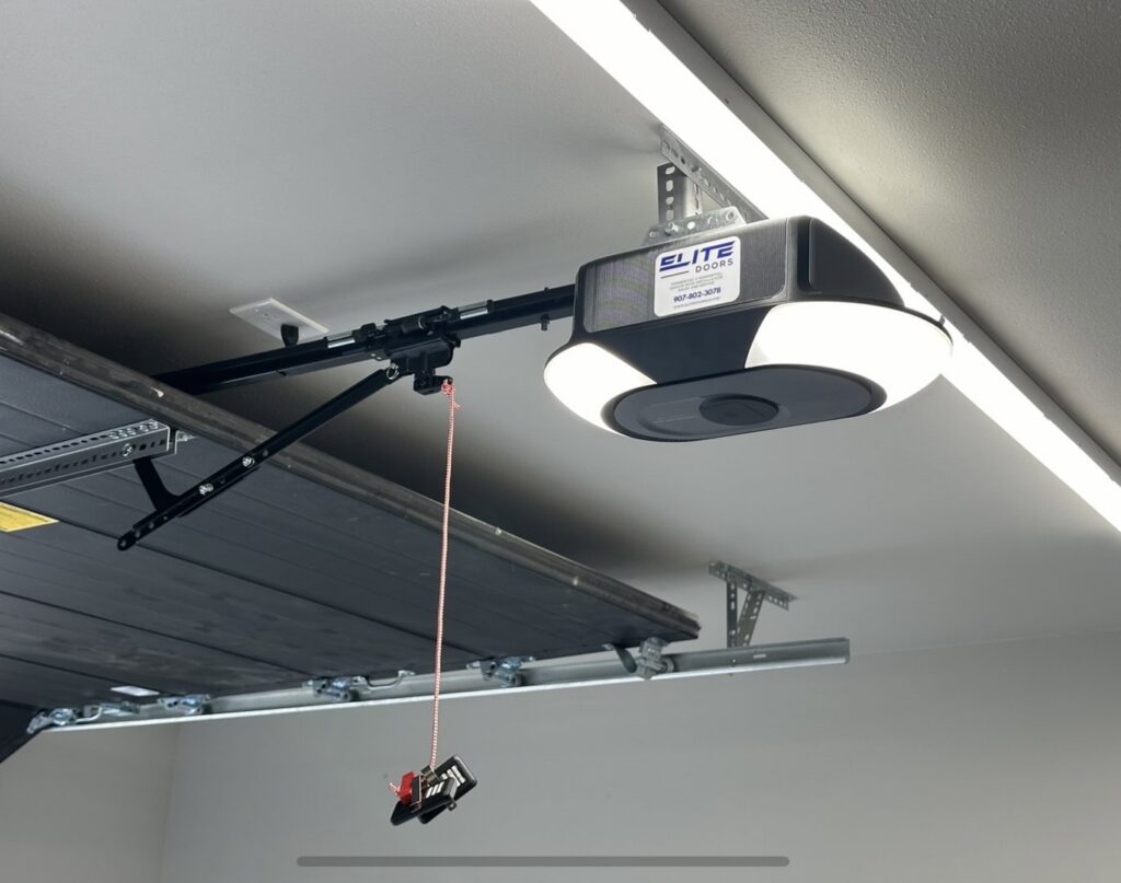 A modern garage door opener with the Elite Doors logo, professionally installed by Elite Doors in Wasilla, AK.