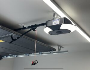 A modern garage door opener with the Elite Doors logo, professionally installed by Elite Doors in Wasilla, AK.