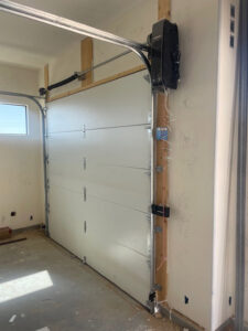 Interior view of a newly installed white garage door and opener system by Quality-Brand Garage Doors in Rio Rancho, NM.