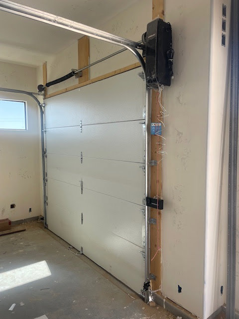 Interior view of a newly installed white garage door and opener system by Quality-Brand Garage Doors in Rio Rancho, NM.