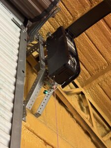 A garage door opener unit and its mounting brackets being installed by Ultimate Garage Doors LLC in Olive Branch, MS.