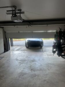 An inside view of a garage showing a partially open door and the opener mechanism, serviced by Windsor Door Sales Inc. in Ogden, UT.