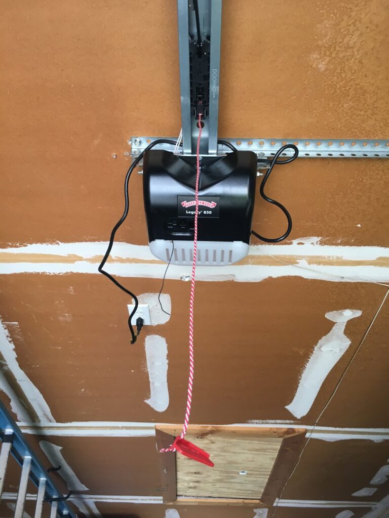 A close-up of a garage door opener motor unit installed on a garage ceiling by Overhead Door Company of Albuquerque in Albuquerque, NM.