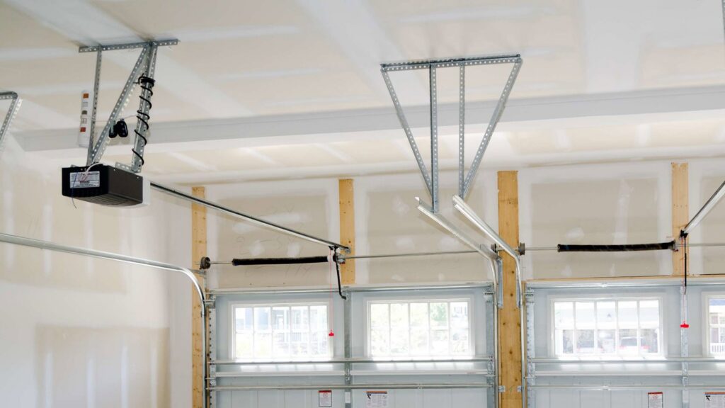 Close-up of garage door opener, springs, and tracks, showing repair or installation by 74 Garage Door Company in Lake Park, FL