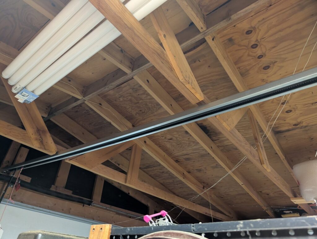 The track system for a garage door opener installed in a residential garage by Overhead Door Company of Santa Fe in Santa Fe, NM.