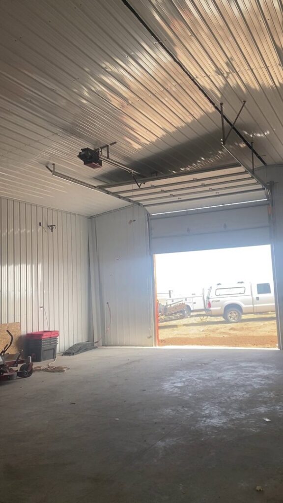 An interior view of a white garage door partially open, showing the opener and tracks installed by Apex Garage Doors in Columbus, OH.
