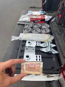 Various garage door parts and tools laid out in a truck bed, ready for a job by Lifetime Garage Door in Las Vegas, NV.