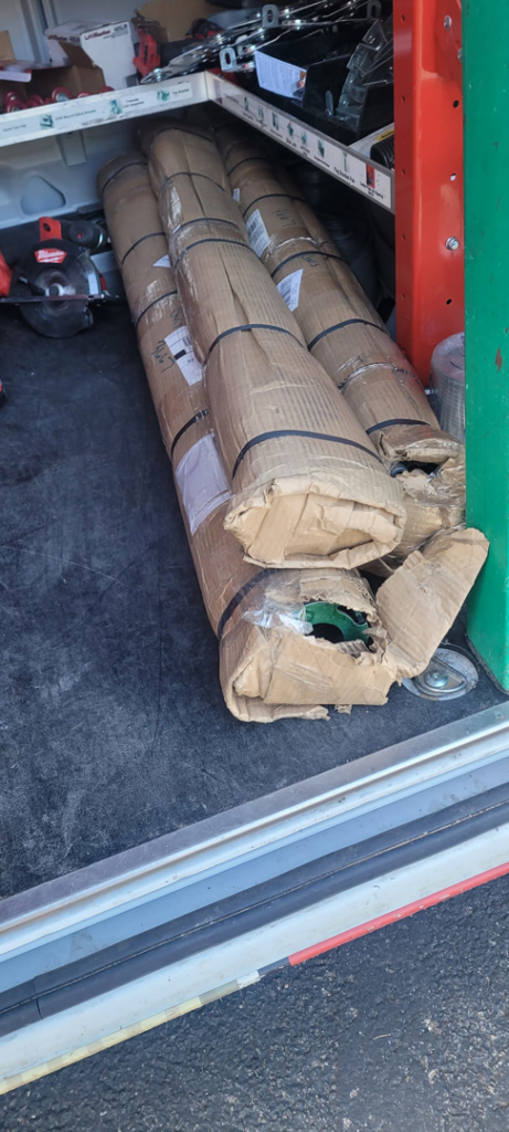 Garage door parts and materials, likely springs or tracks, stored in a work van by A1 Garage Guy Wes in Picture Rocks, AZ.