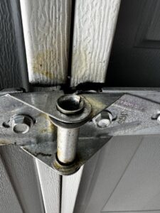 A close-up view of a garage door roller and hinge, indicating repair or replacement by Apex Garage Doors LLC in Las Vegas, NV