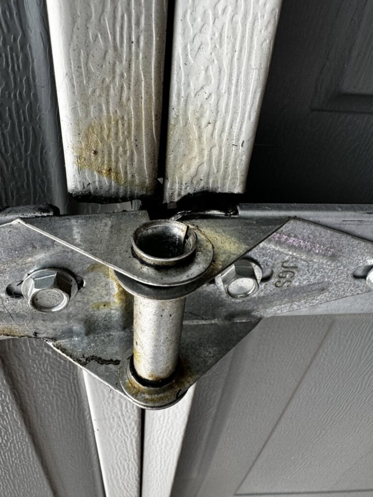 A close-up view of a garage door roller and hinge, indicating repair or replacement by Apex Garage Doors LLC in Las Vegas, NV