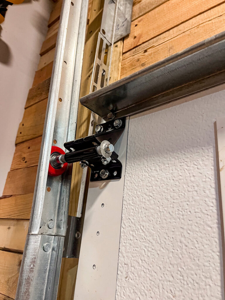 Close-up of a garage door roller and track system, showing components serviced by Over The Top Garage in Albuquerque, NM.