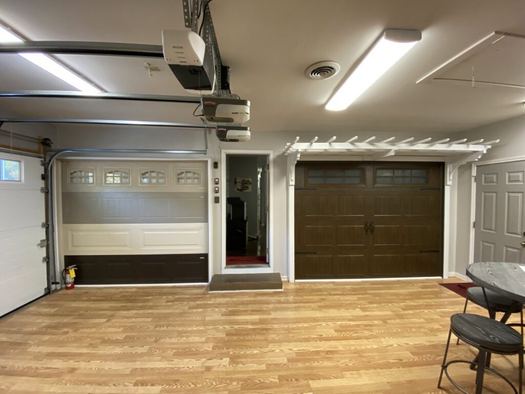 An interior view of a garage door showroom displaying various door samples and installed doors by Overhead Door Company of Little Rock in North Little Rock, AR.