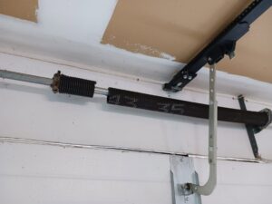 Close-up of a garage door torsion spring and chain drive mechanism, indicating repair by Up & Down Garage Doors in Bridgeport, CT.