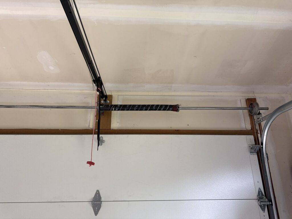 Interior view of a garage door spring system and tracks installed by Mascolo Overhead Doors & Maintenance in Brookfield, CT.
