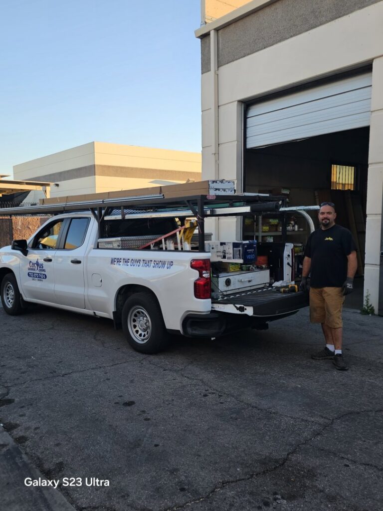 A technician from Cactus Garage Doors, Inc. standing by a service truck at a job site in North Las Vegas, NV.