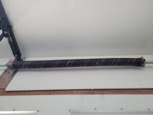Close-up of a garage door torsion spring assembly, ready for repair or replacement by Klondike Door Service in Fairbanks, AK
